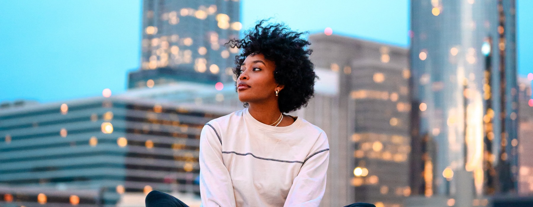 lifestyle image of a woman in front of a city skyline